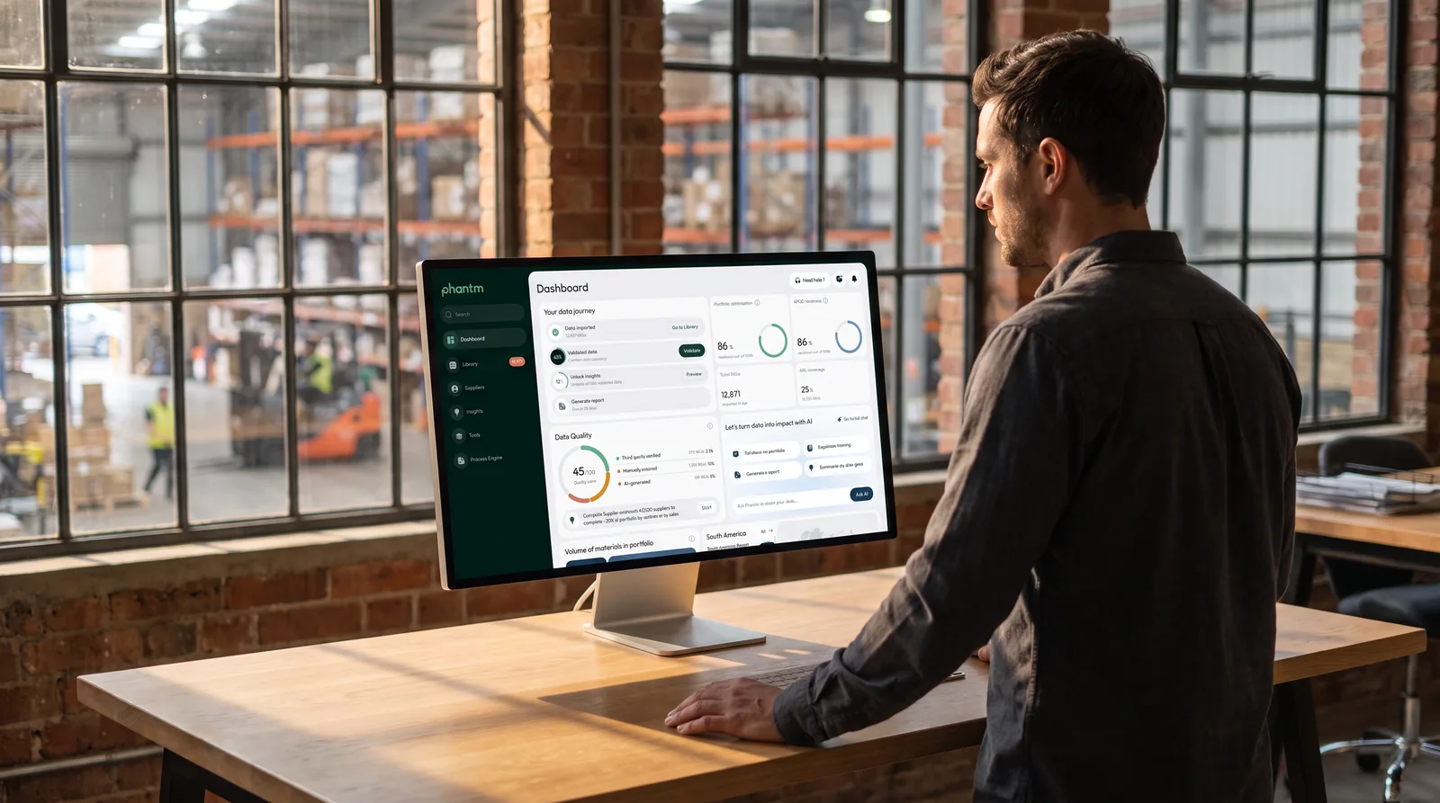 A team member reviewing the Phantm dashboard on a large display in a warehouse workspace.